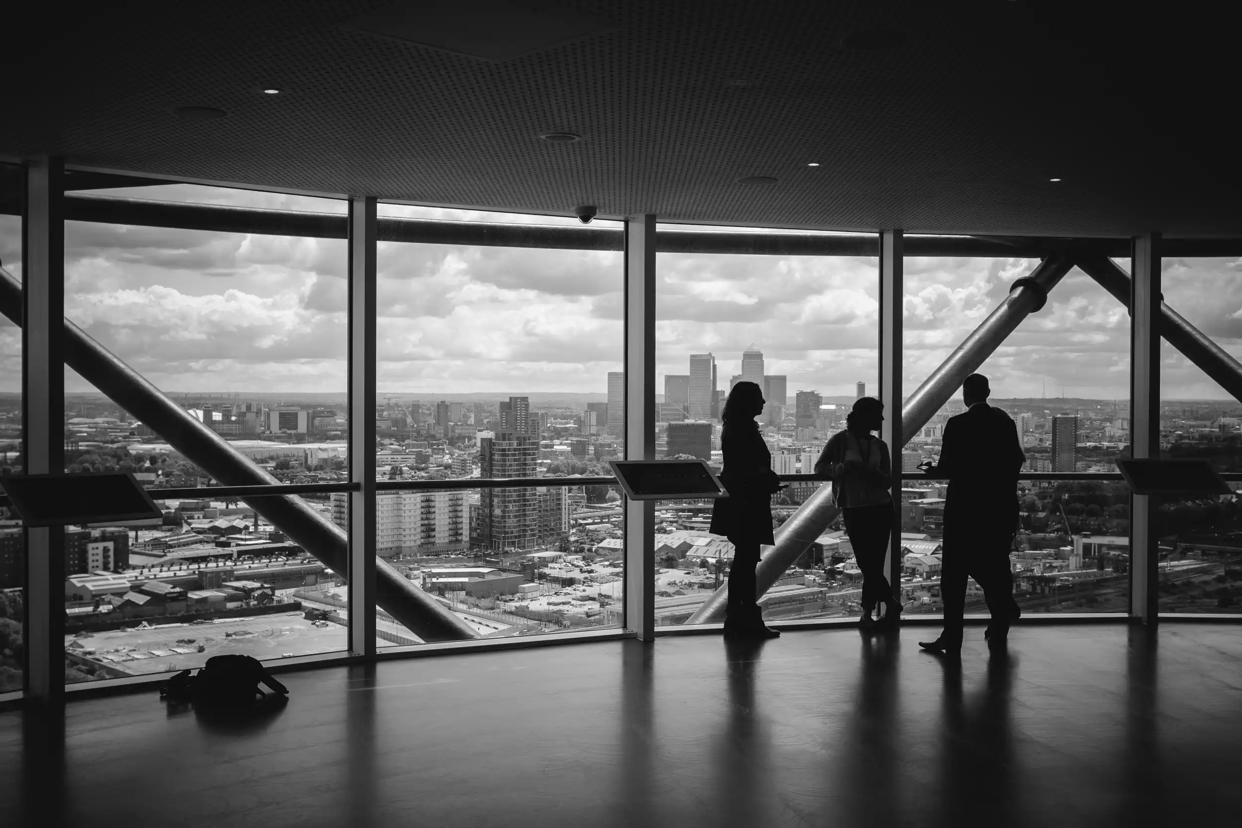 Espace de bureau avec personnes debout près de la fenêtre. Image en noir et blanc