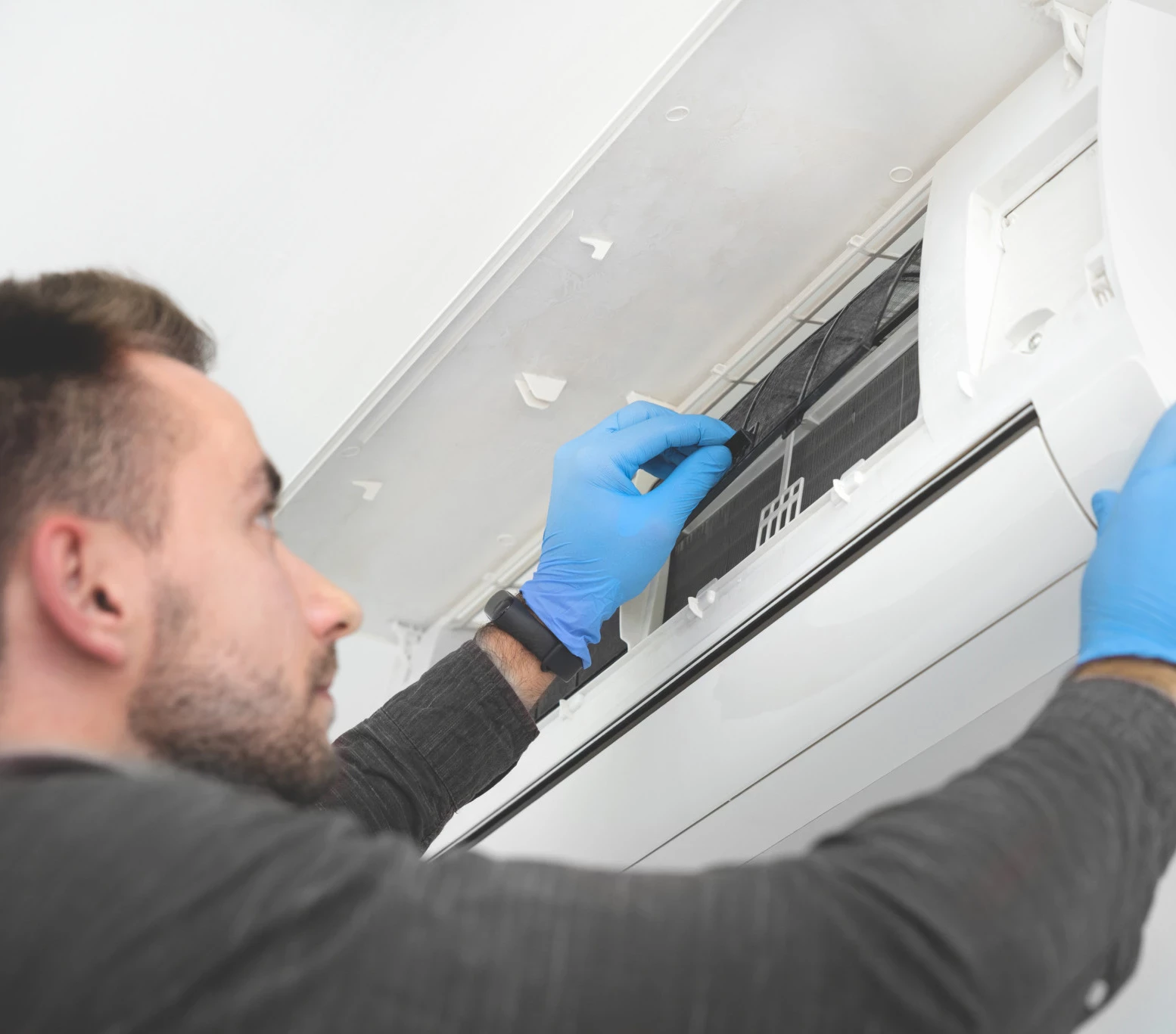technicien nettoyant climatiseur murale